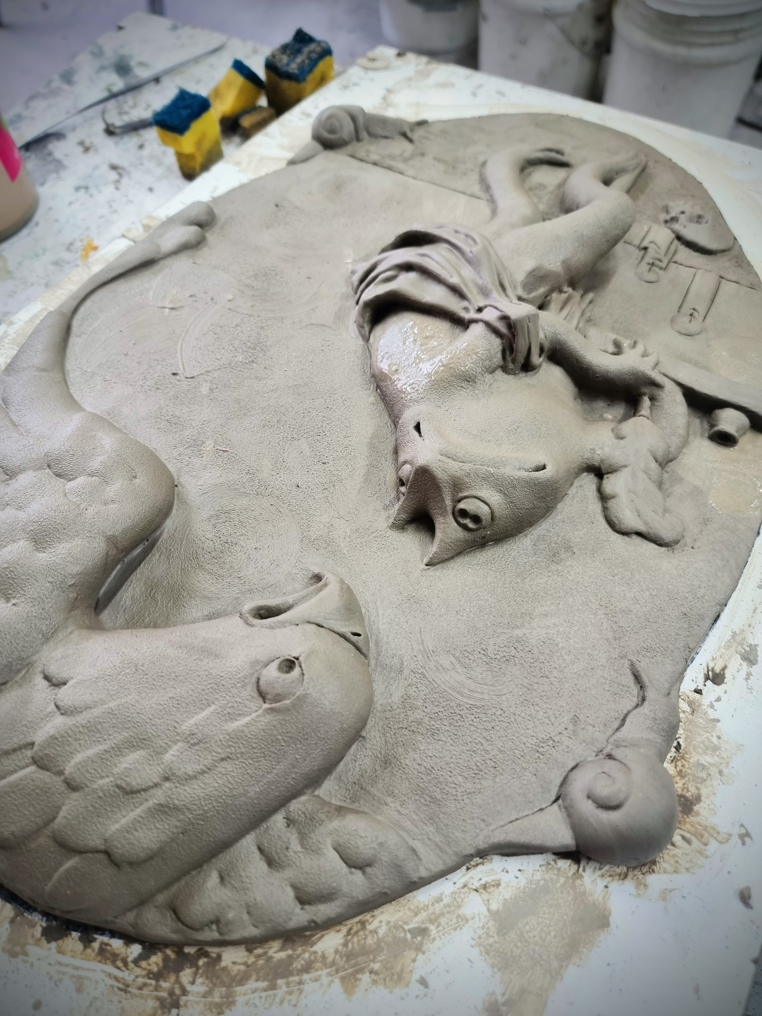 A clay relief being sculpted